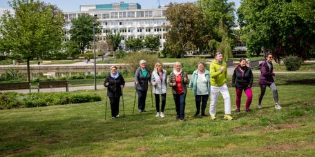 Patienten trainieren Nordic-Walking vor der Klinik