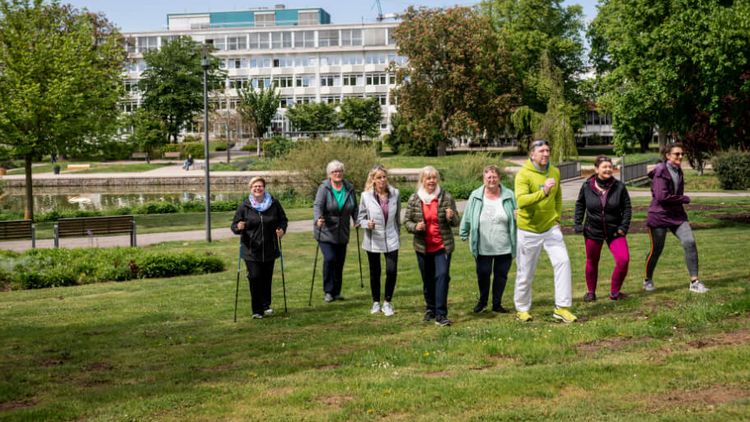 Patienten trainieren Nordic-Walking vor der Klinik