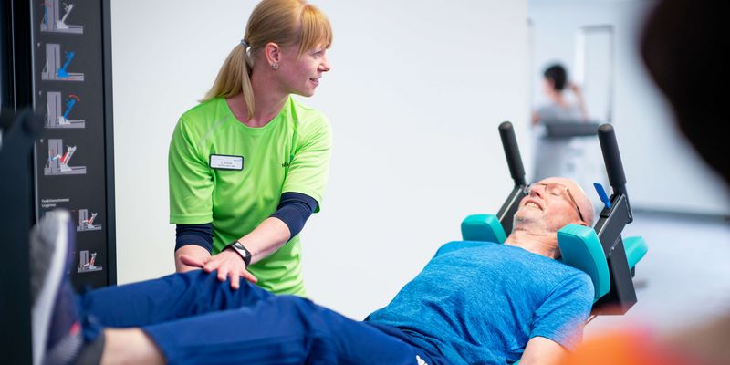 Therapeutin unterstützt patienten bei Gerätetraining