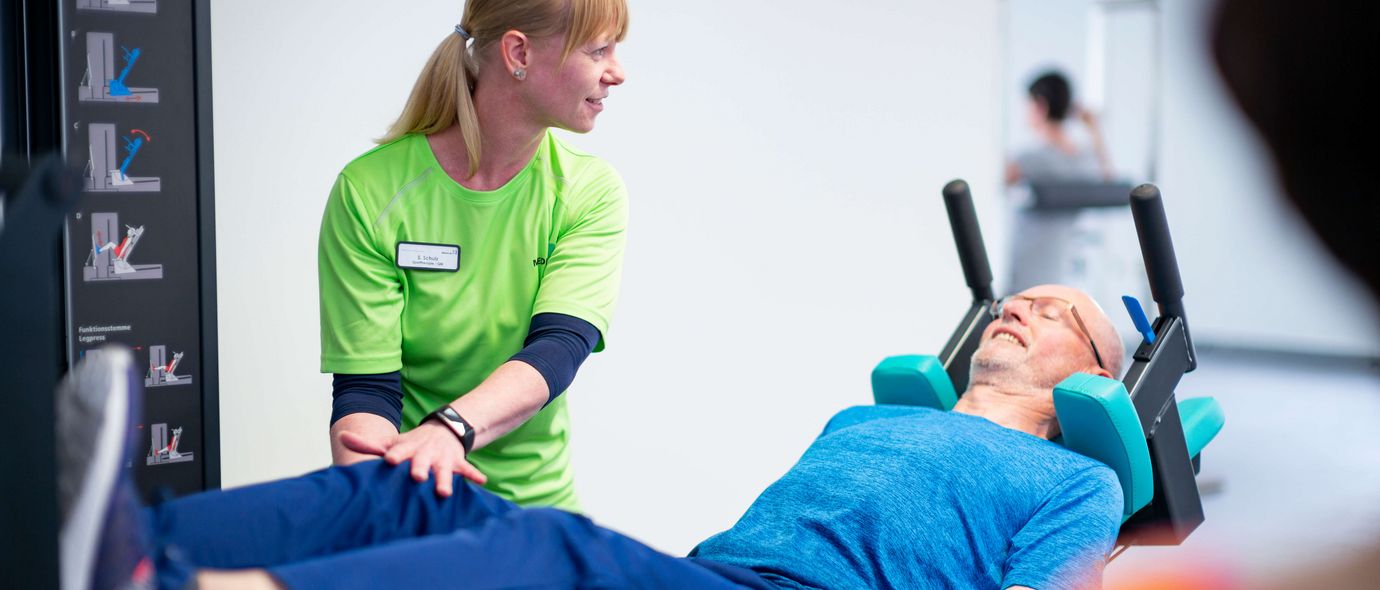 Therapeutin unterstützt patienten bei Gerätetraining